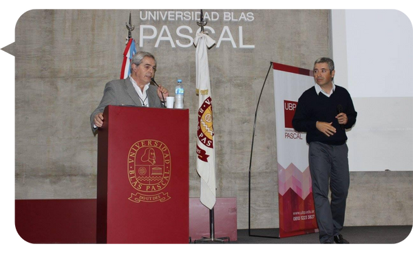 Cristian Martín Maqui ofreciendo una conferencia en la Universidad Blas Pascal, hablando desde el podio.