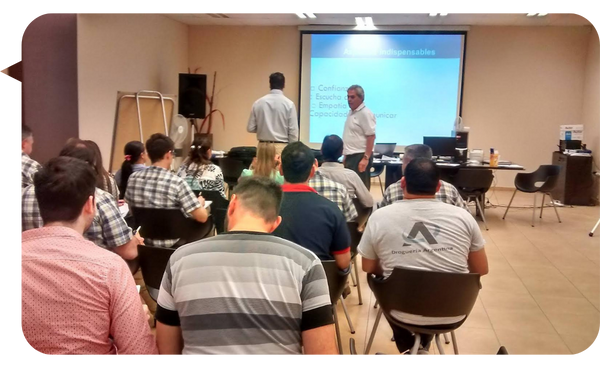 Cristian Martín Maqui impartiendo un taller a un grupo de personas, con una presentación proyectada en la pantalla.