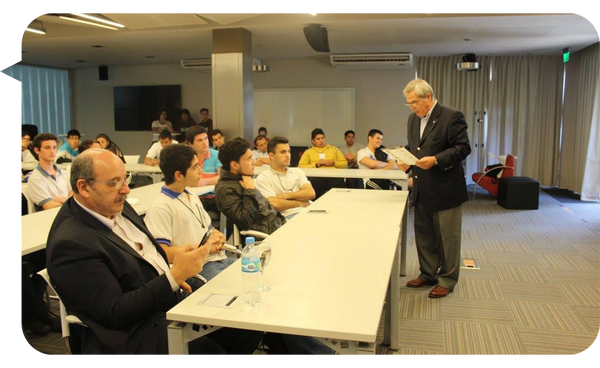 Cristian Martín Maqui dando una clase o conferencia a un grupo de estudiantes y profesionales en un aula.