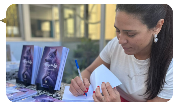 Fabiana Matos firmando un ejemplar de su libro en un evento.