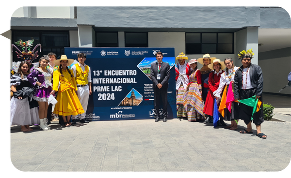 Javier Alejandro Pierre en el 13° Encuentro Internacional PRME LAC 2024 junto a un grupo de bailarines con trajes típicos.